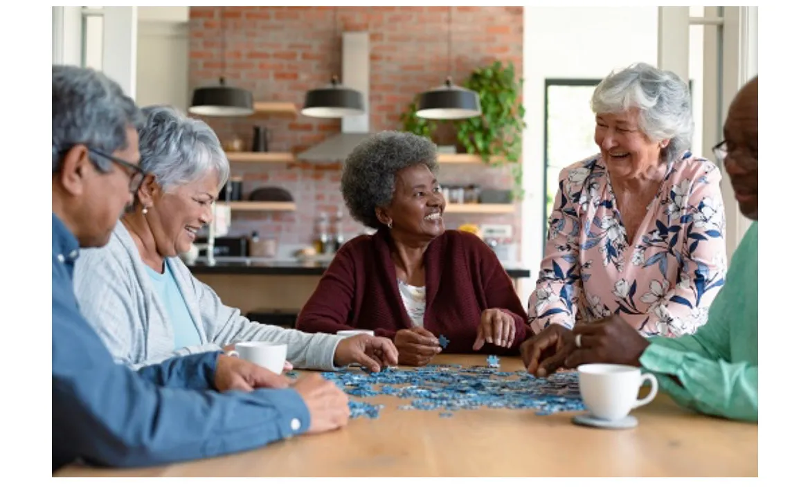 Seniors working on a puzzle together around a kitchen table