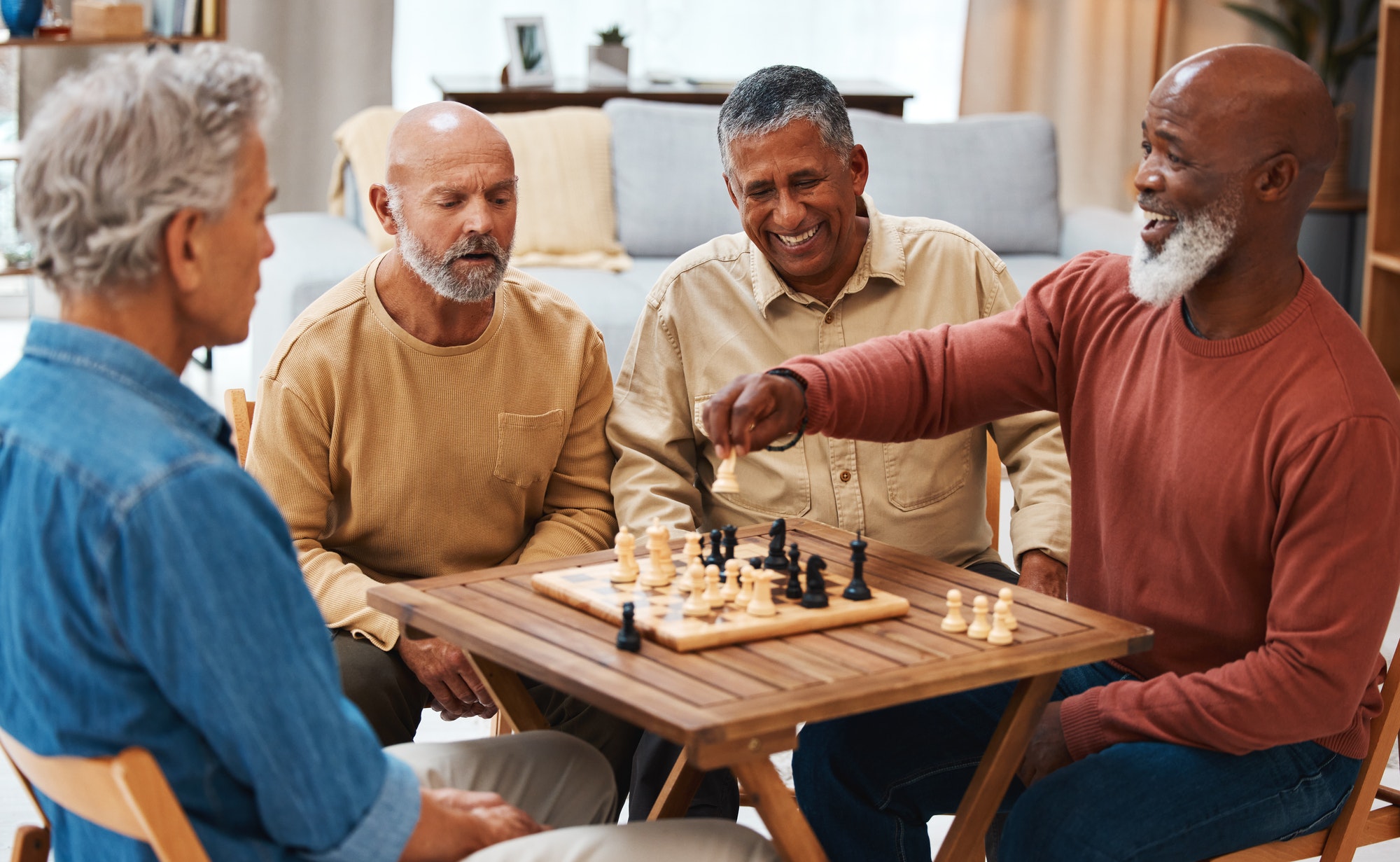 Chess, friends and board games on wooden table for strategic, cocky or tactical move at home. Senio